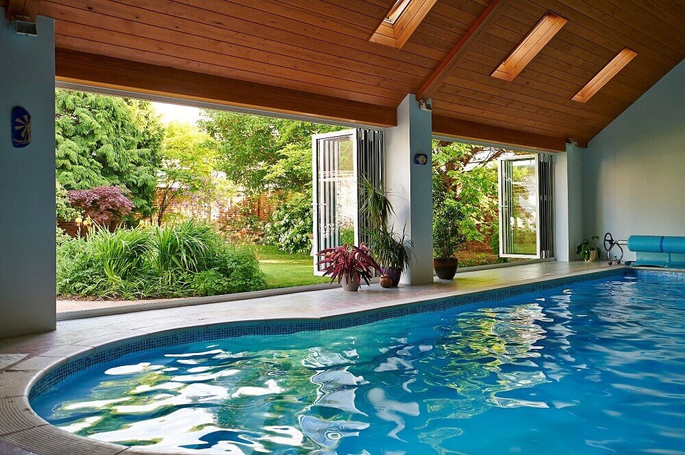 An indoor swimming pool with bi fold doors. 