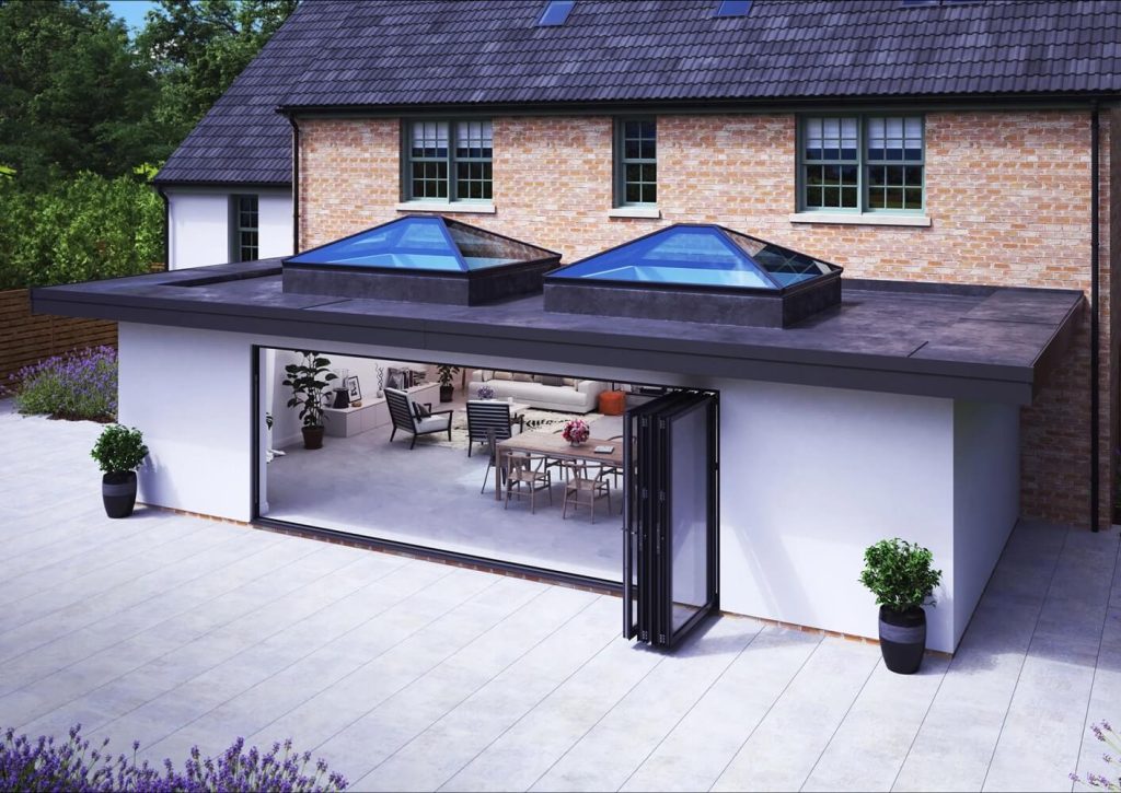 This image showcases a modern home extension with two Korniche roof lanterns installed side by side. The lanterns flood the open-plan interior with natural light and highlight the sleek, contemporary design of the space.